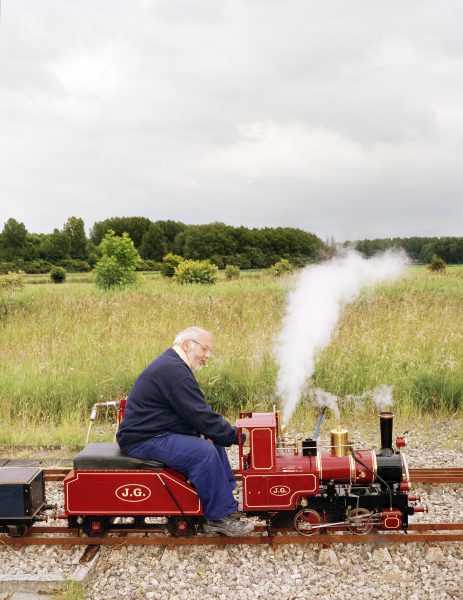 Jan Dirk van der Burg op een rode modelbouw locomotief